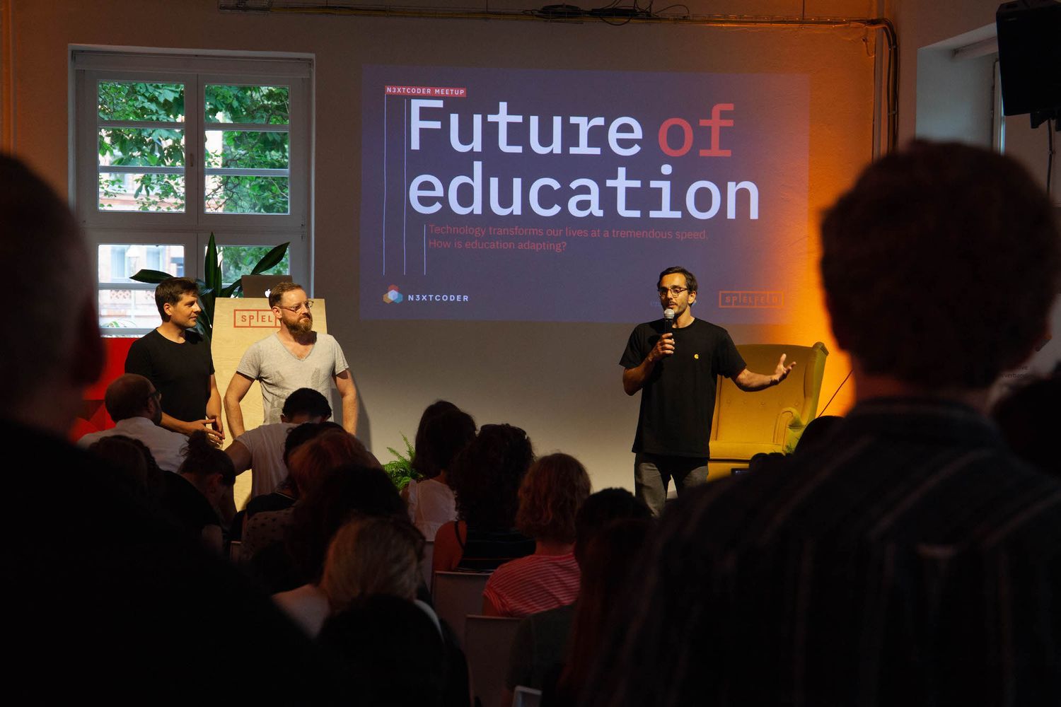The Nextcoder founders Simon Stegemann, Jonathan Moore and Leonhard Nima standing in front of the future of education presentation.