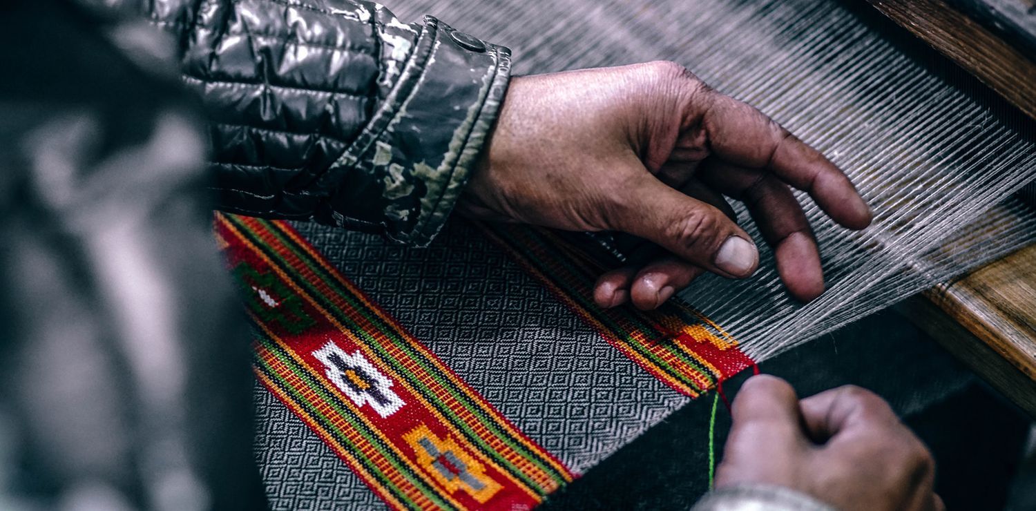 Bild der Hände eines Mannes, der einen Teppich herstellt